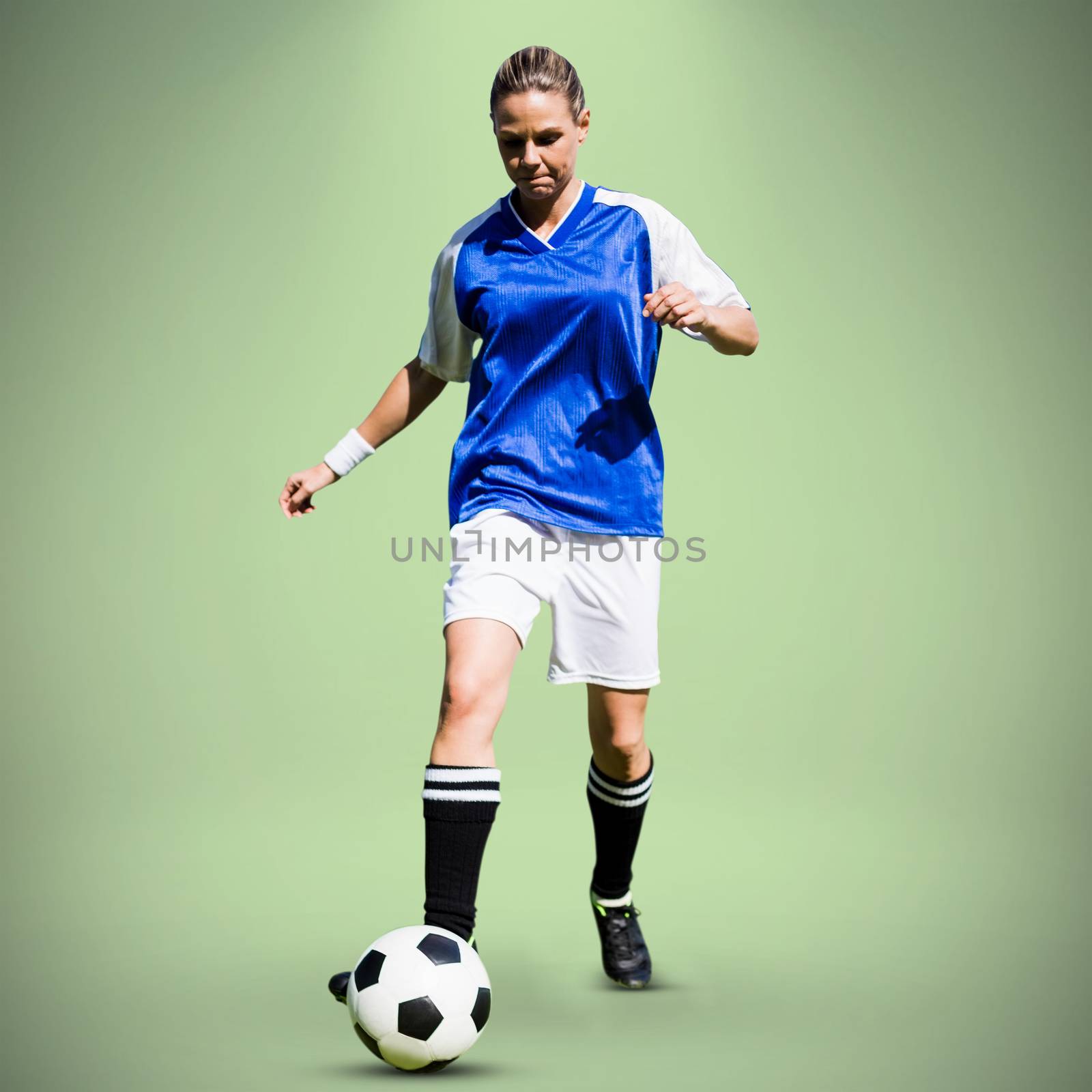 Composite image of woman soccer player progressing with a ball by Wavebreakmedia