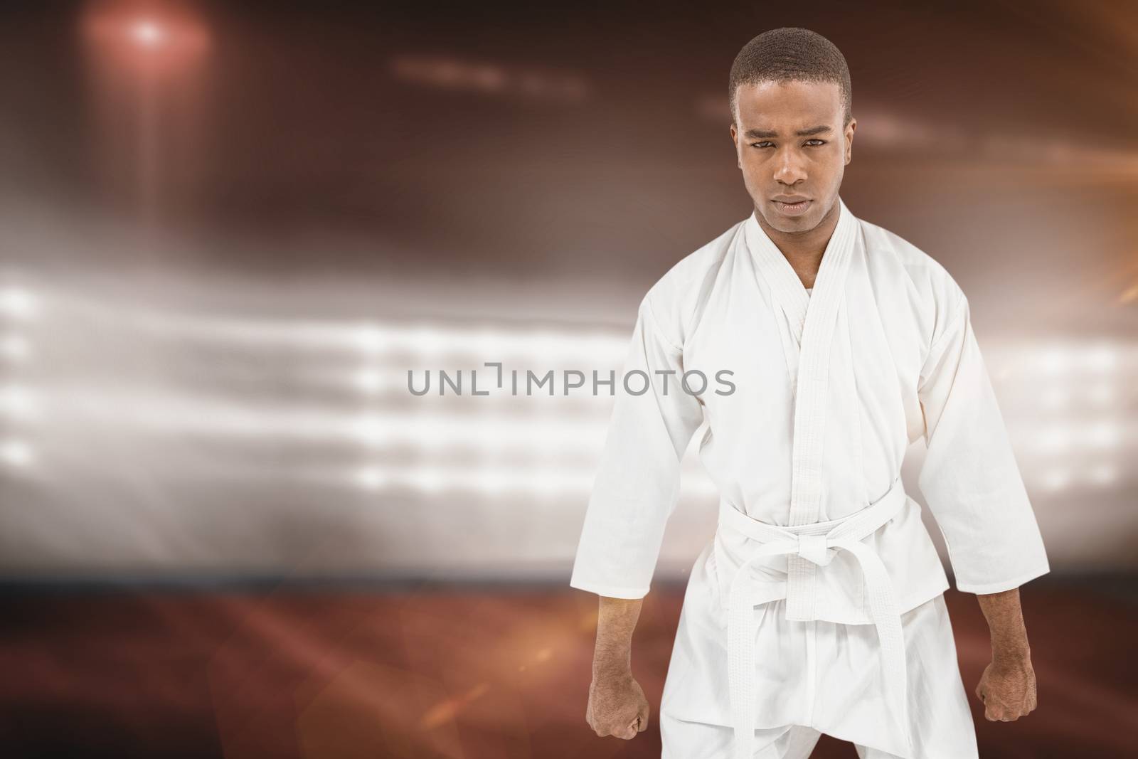 Composite image of front view of karate fighter meditating by Wavebreakmedia