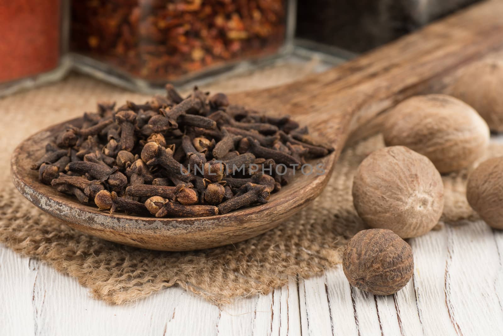 Spice cloves in a wooden spoon on old wooden table.  Selective focus. 