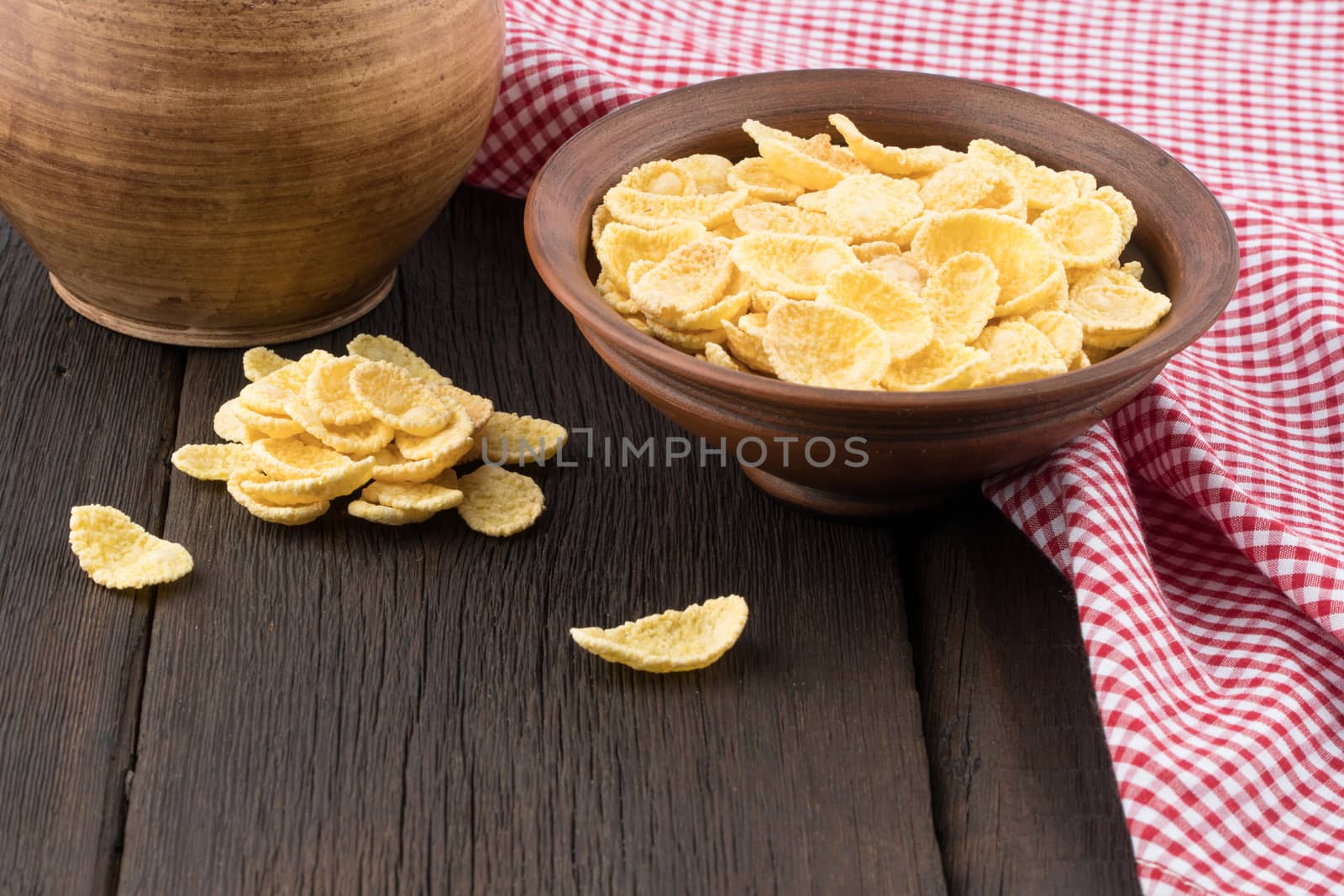 Corn flakes in a ceramic bowl on the old wooden table. Selective focus. 