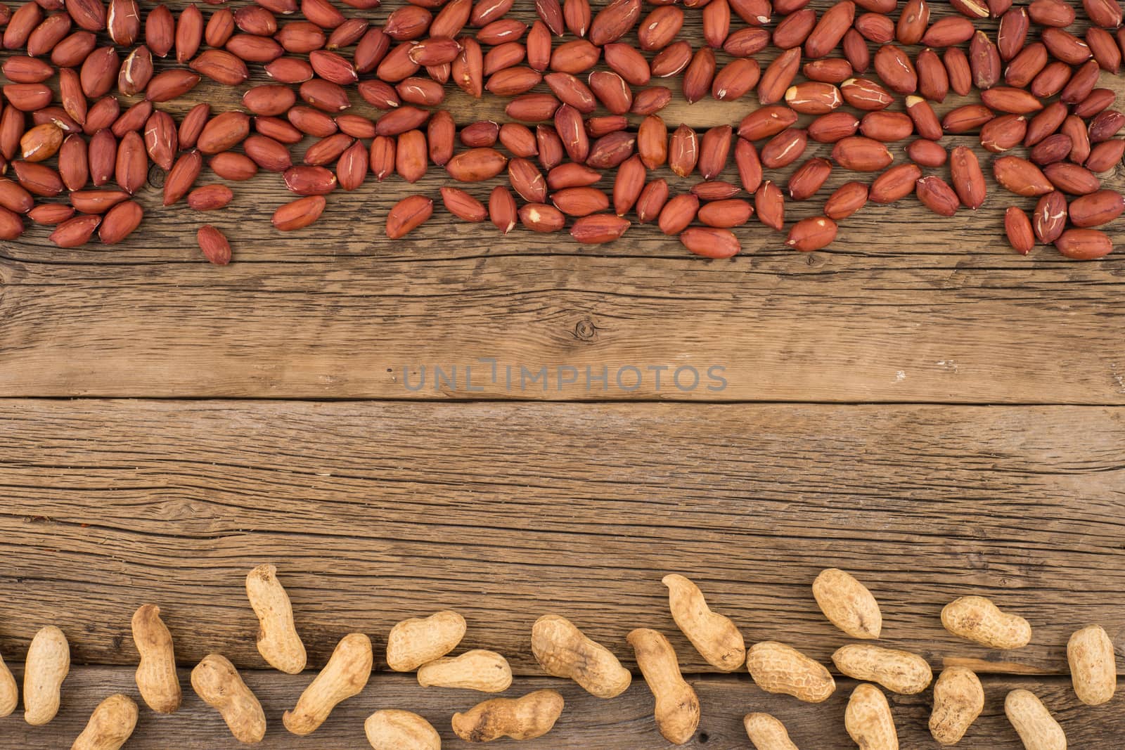 Peanuts on the background of the old wooden table. by DGolbay