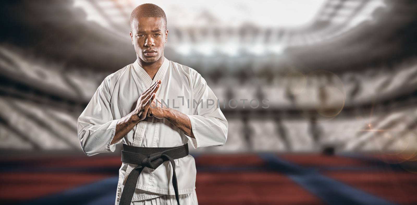 Fighter performing hand salute against digitally generated image of stadium