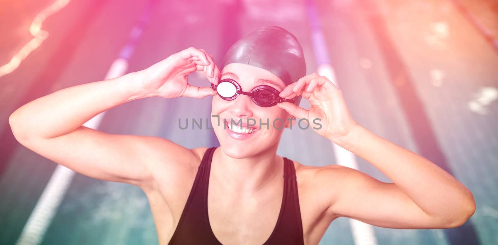 Woman in swimsuit adjusting her goggles at the pool