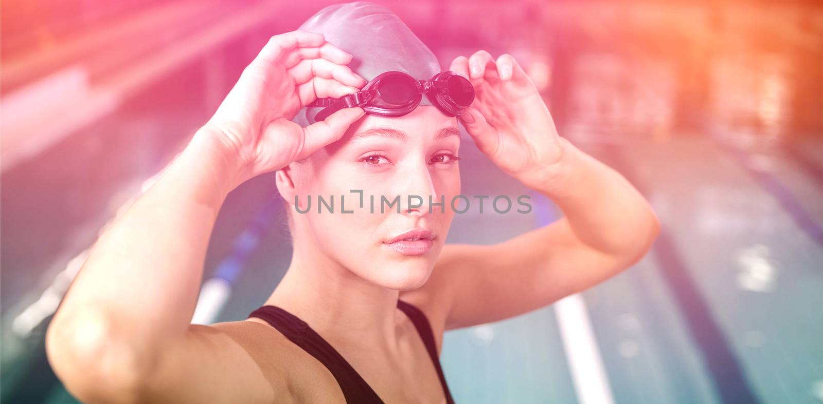 Woman in swimsuit adjusting her goggles at the pool