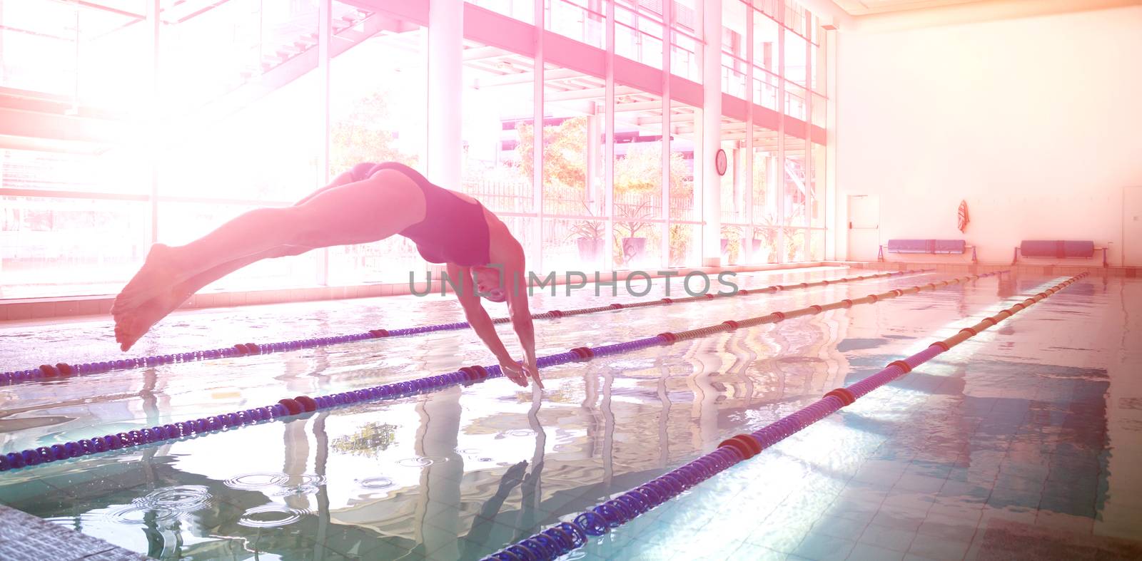 Woman diving in swimming pool at leisure center 