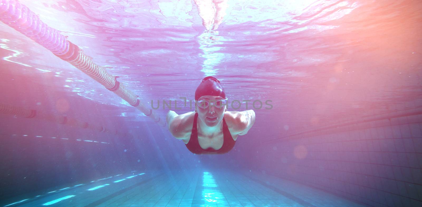 Athletic swimmer training on her own in the swimming pool at the leisure centre