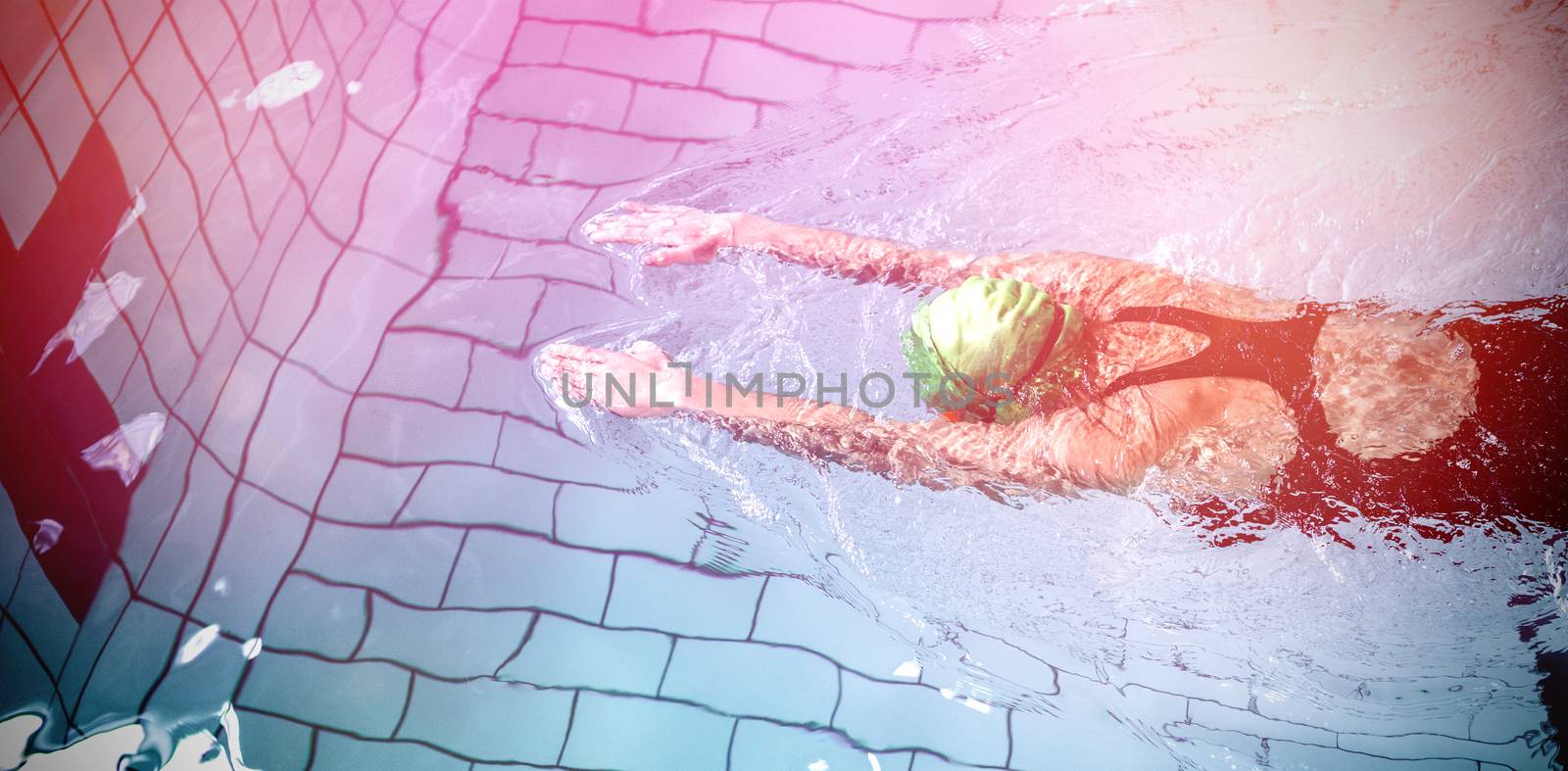 Fit woman swimming with swimming hat in swimming pool