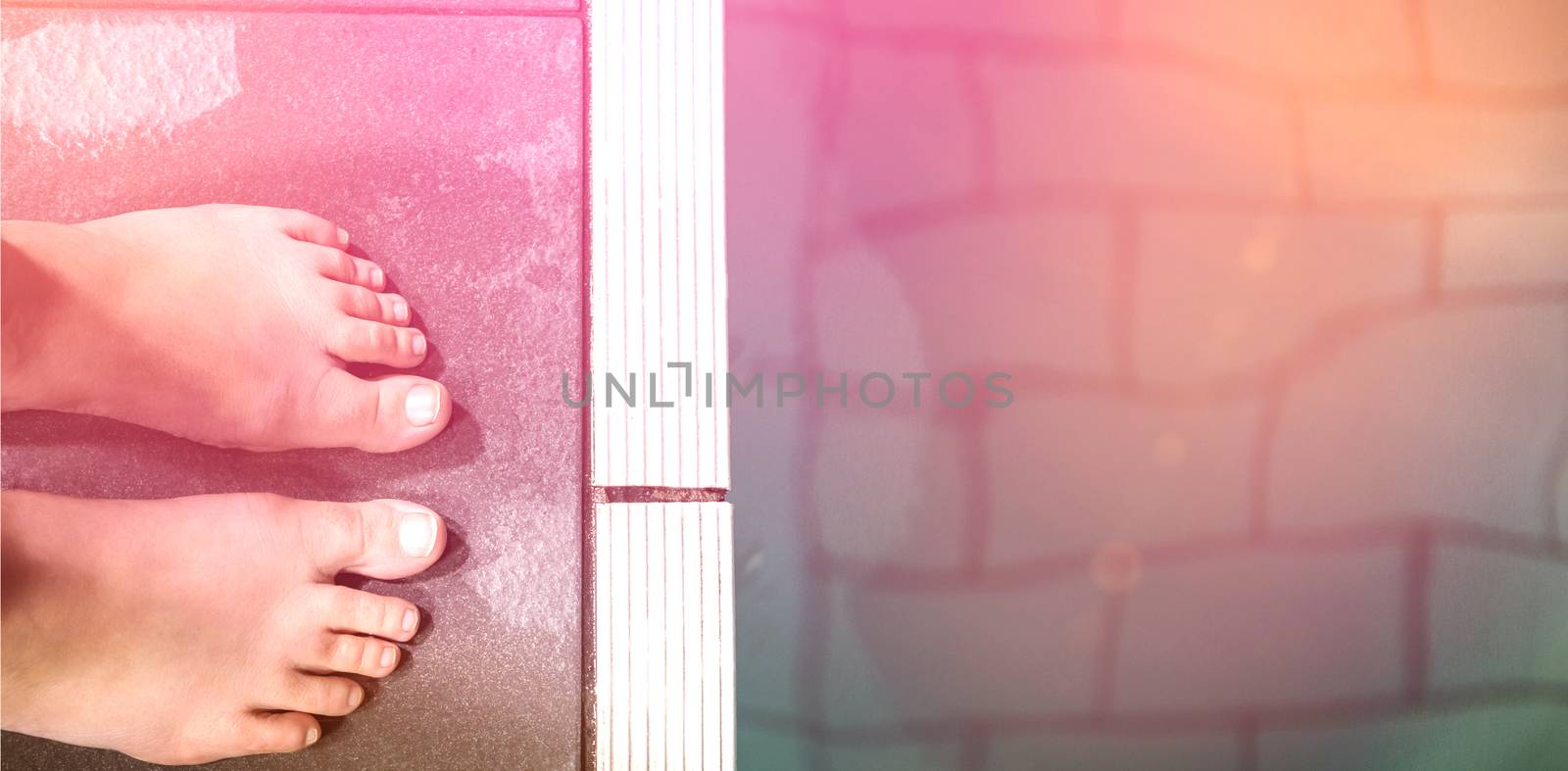 Feet of woman standing on the edge of the pool at the leisure center