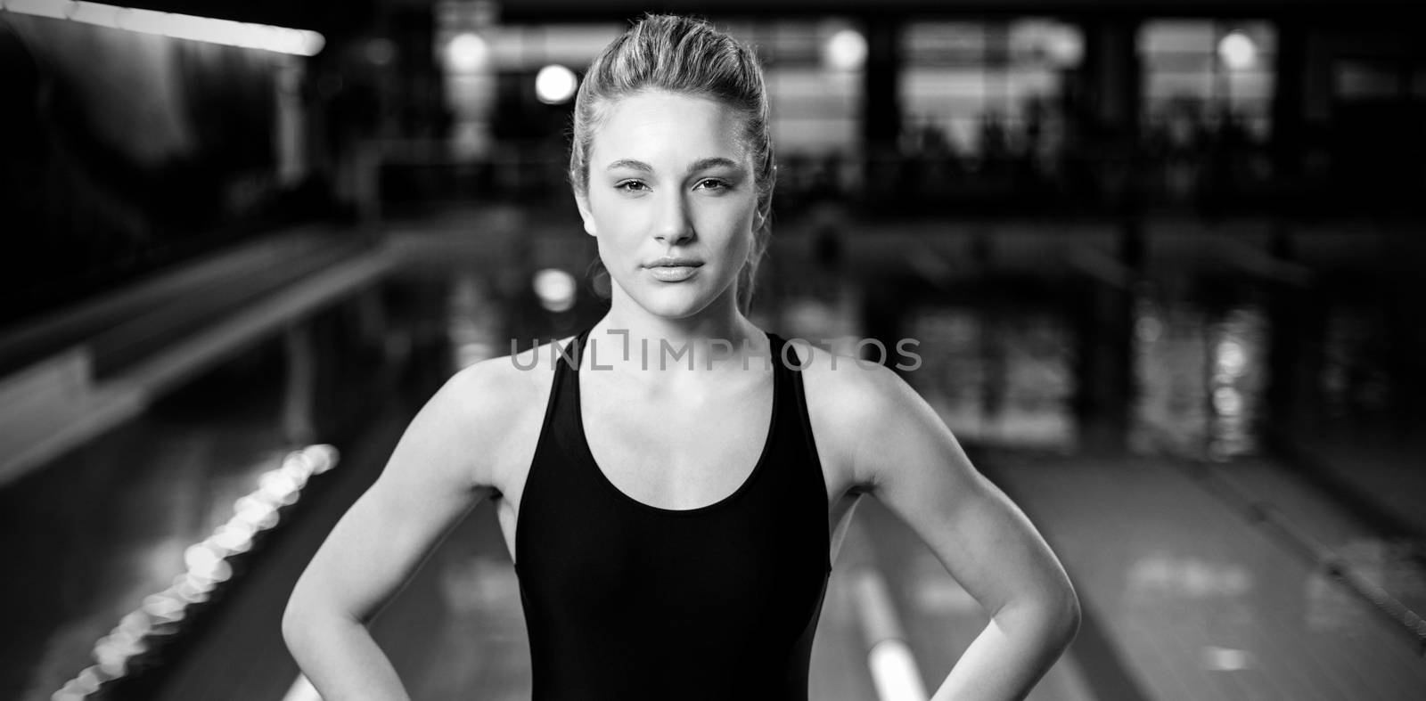 Fit woman with hands on hips at the pool