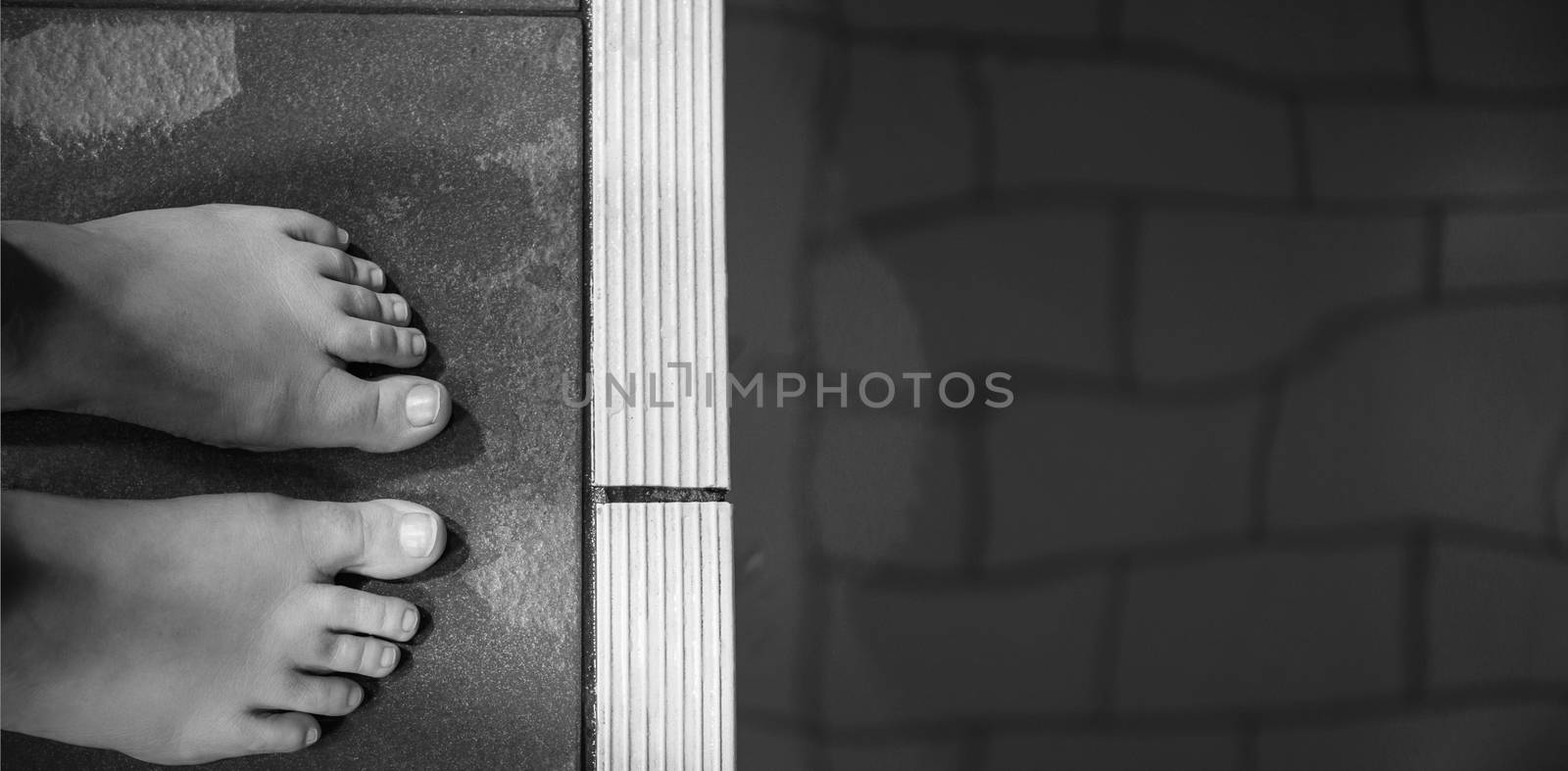 Feet of woman standing on the edge of the pool at the leisure center