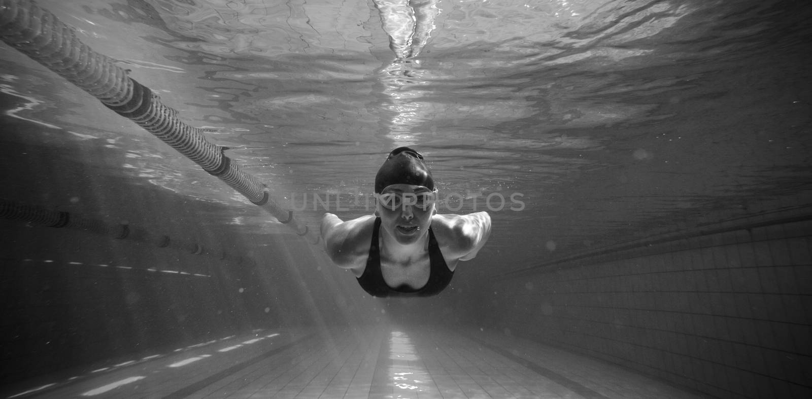 Athletic swimmer training on her own in the swimming pool at the leisure centre