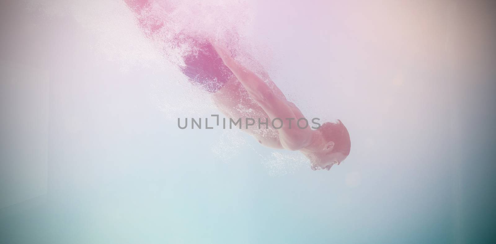 Side view of shirtless man swimming underwater