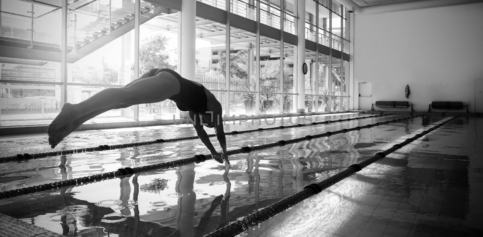 Woman diving in swimming pool at leisure center 