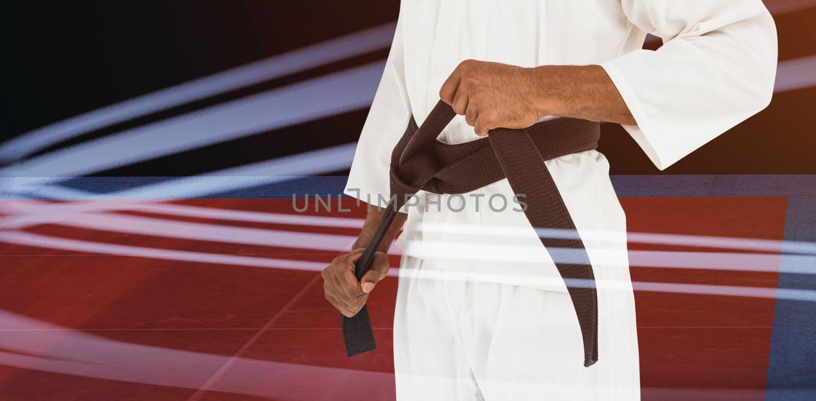 Fighter tightening karate belt against overhead view of playing field