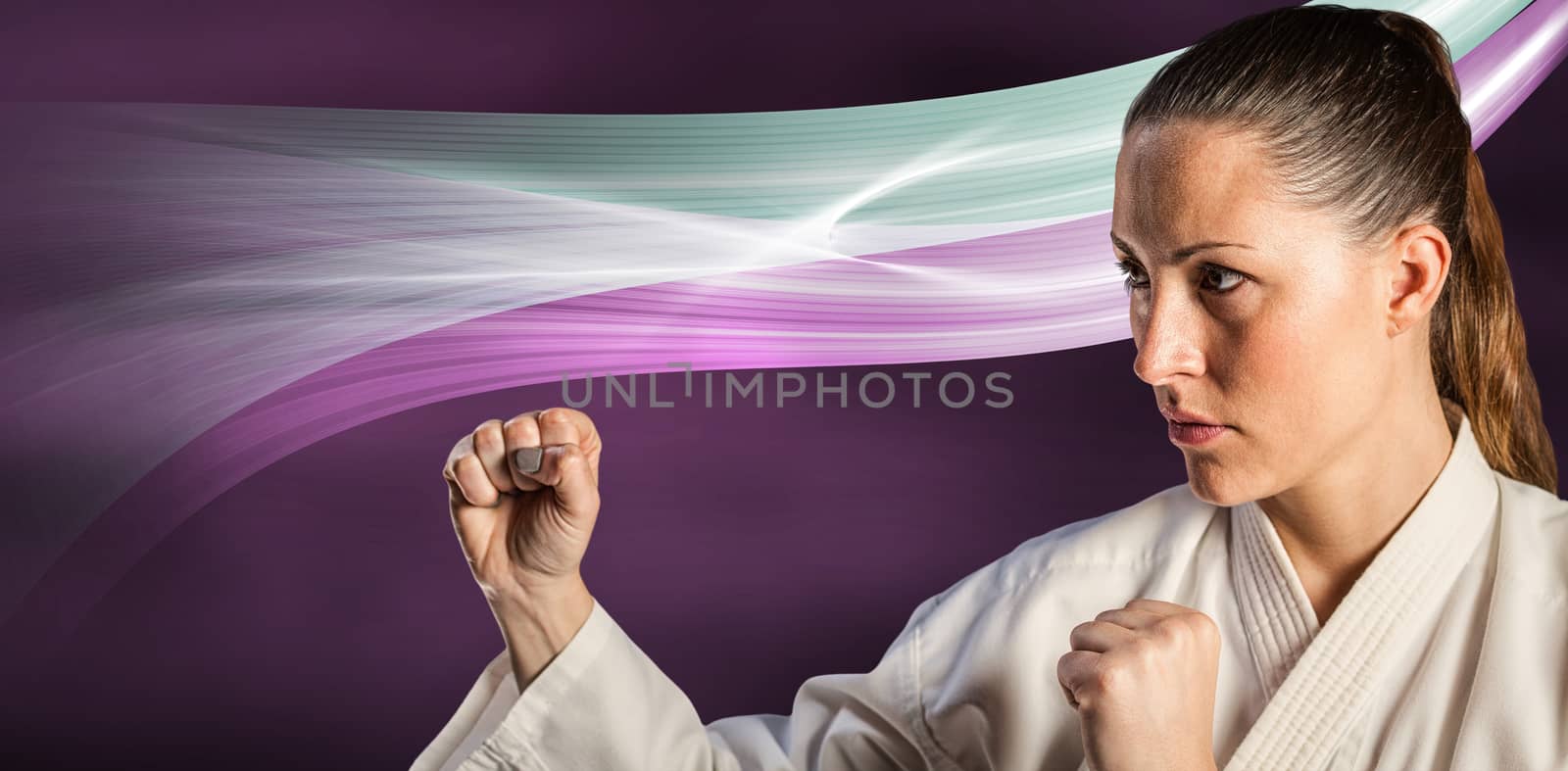 Female fighter performing karate stance against black background