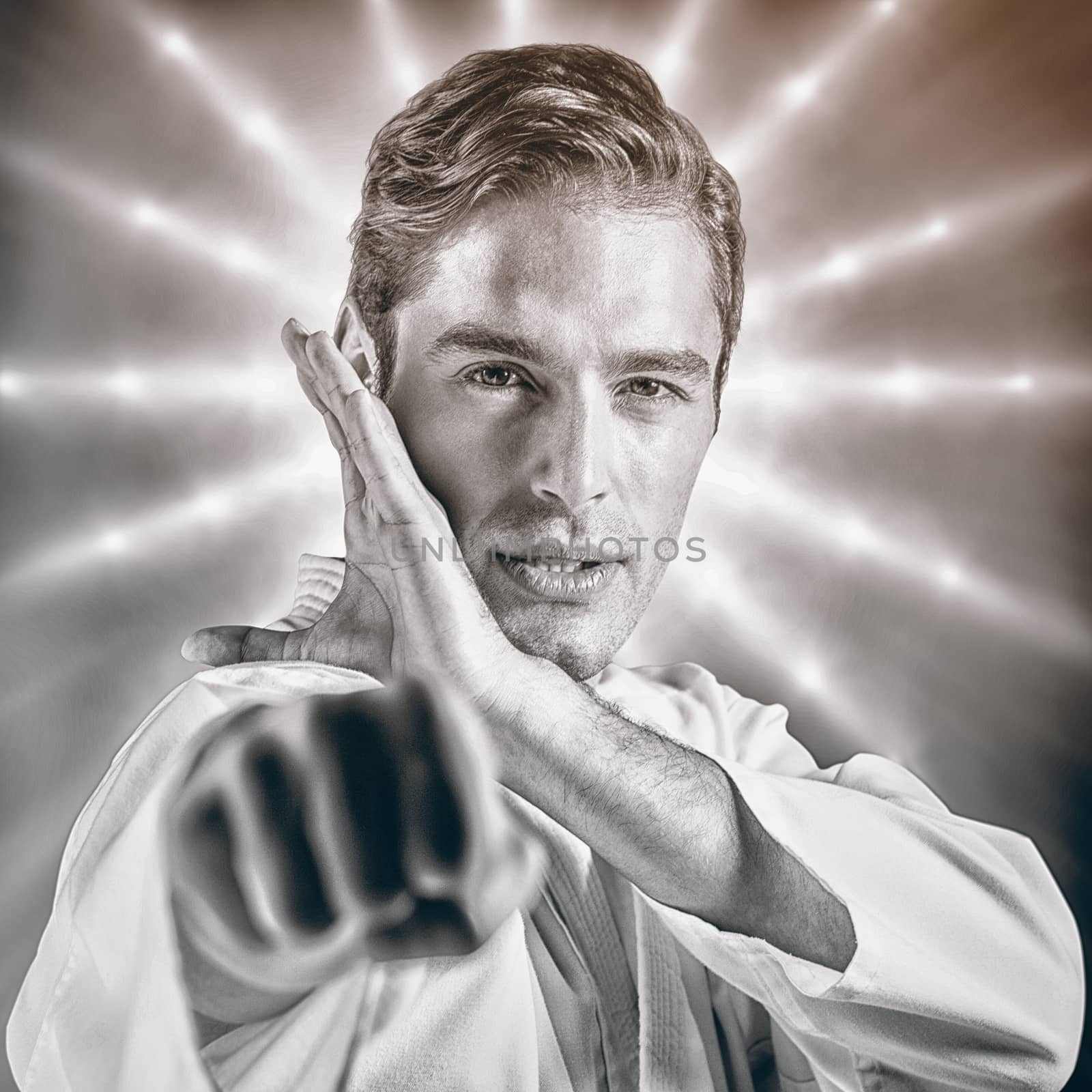 Portrait of fighter performing karate stance against spotlights