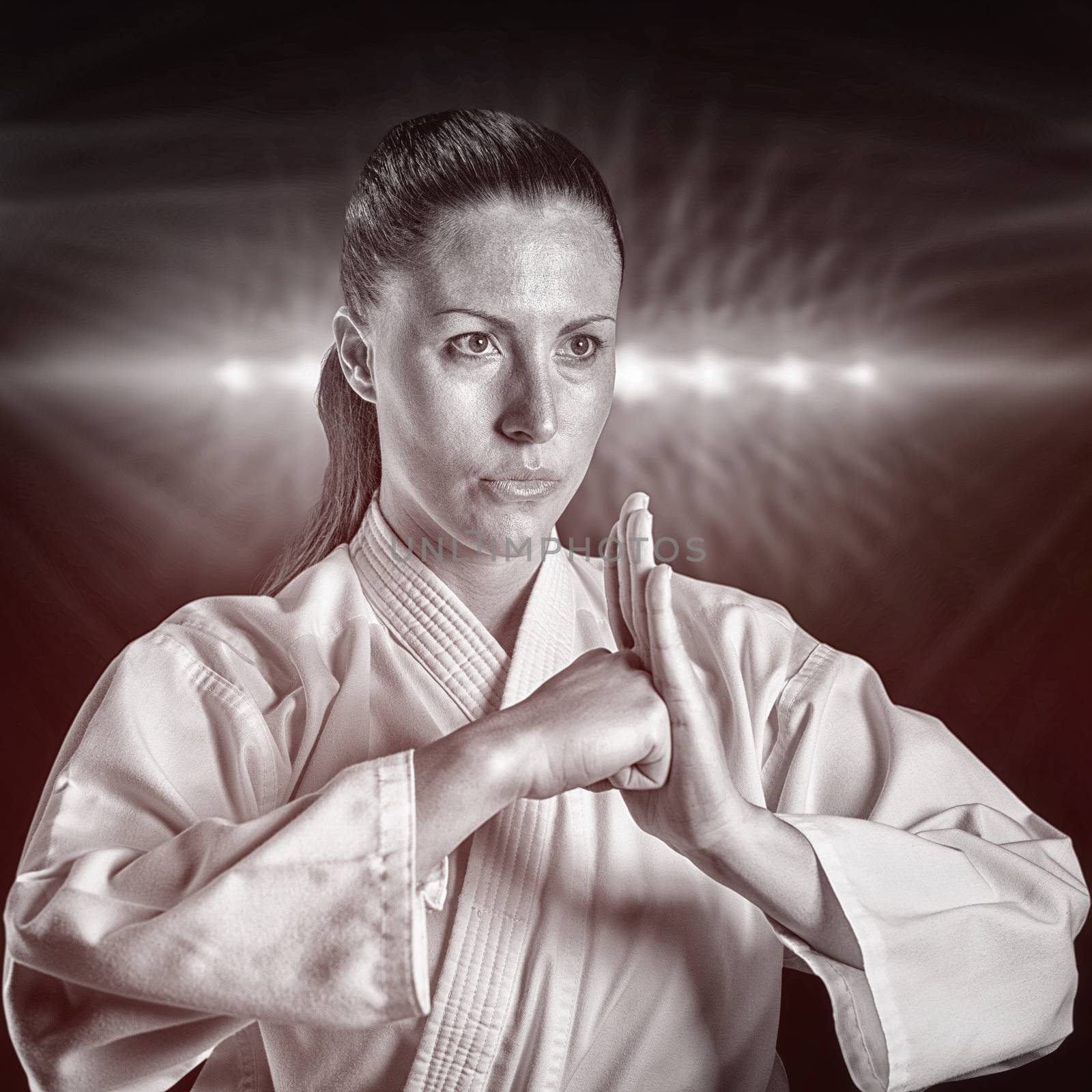 Female fighter performing hand salute against spotlight