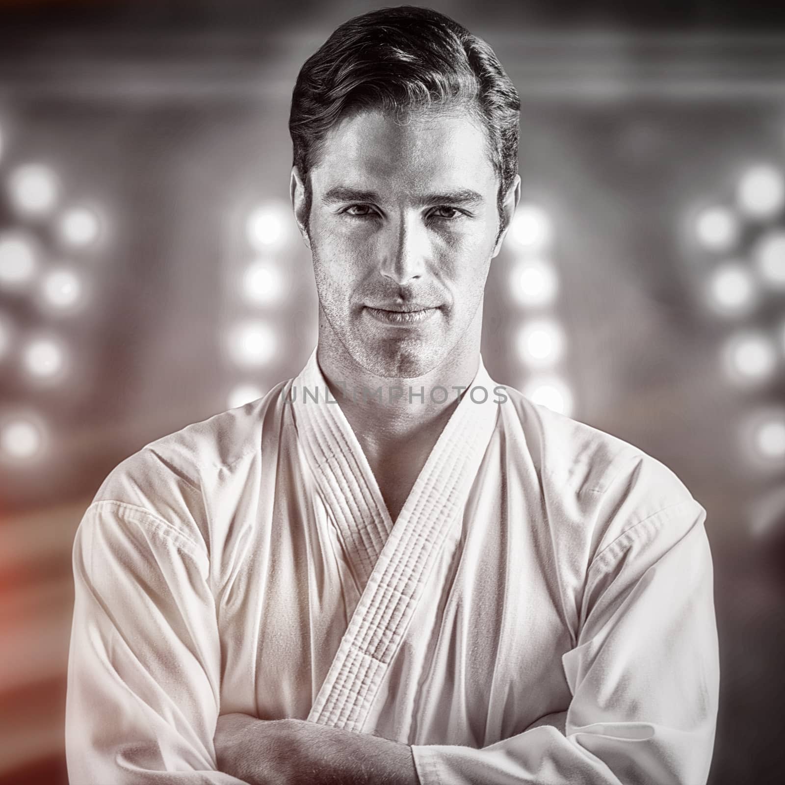 Portrait of fighter standing on black background against digitally generated image of spotlight 