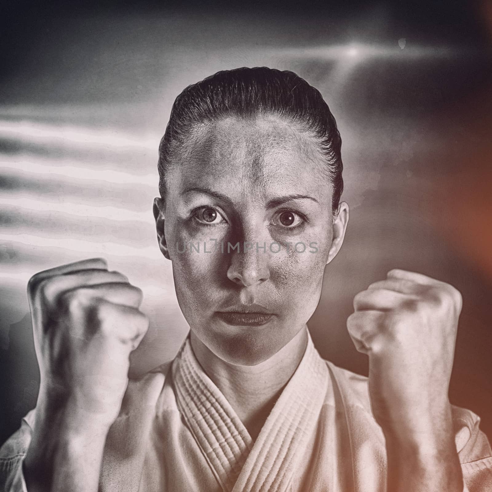 Female fighter performing karate stance against spotlight