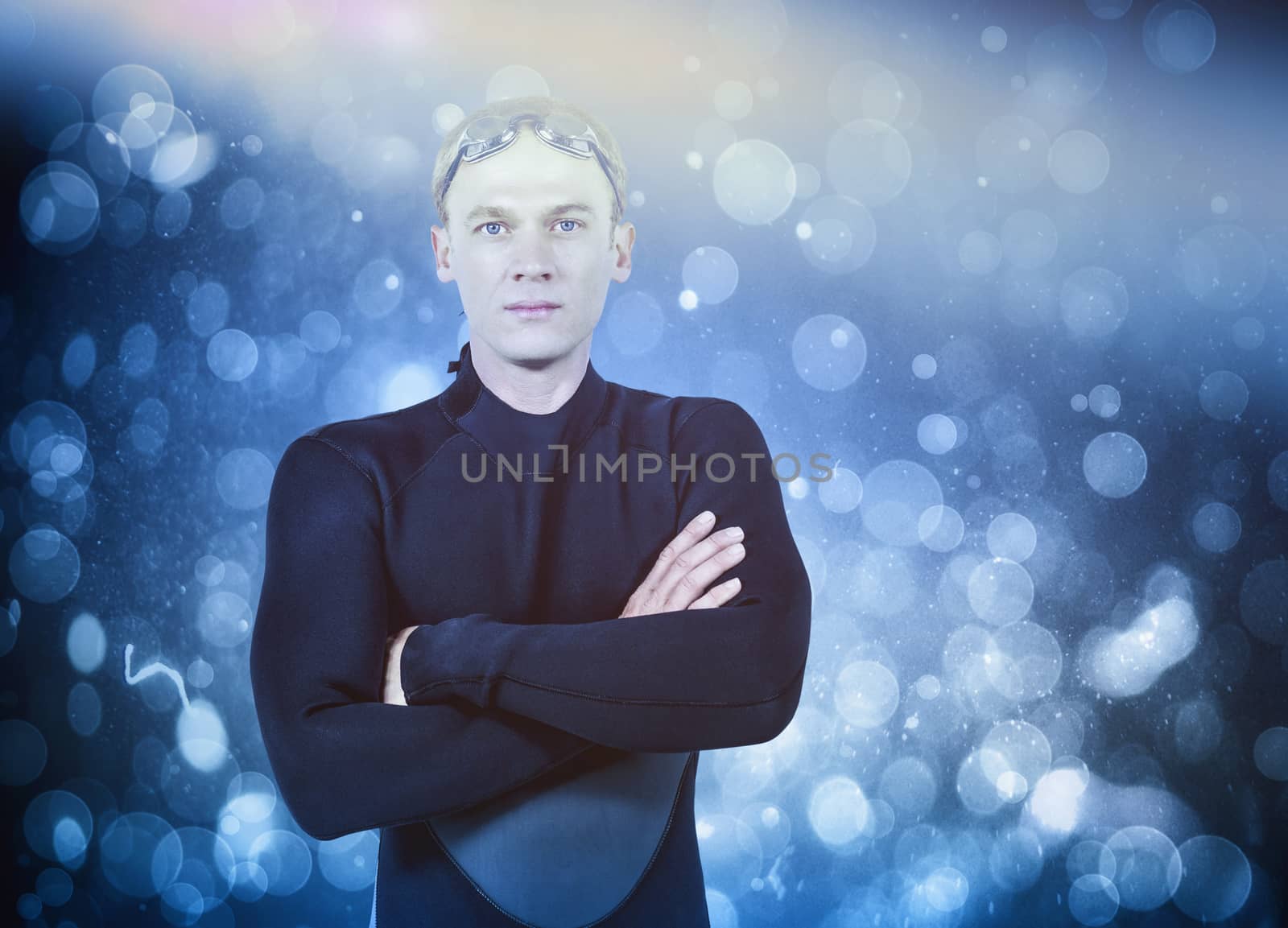 Portrait of swimmer in wetsuit against blue abstract light spot design