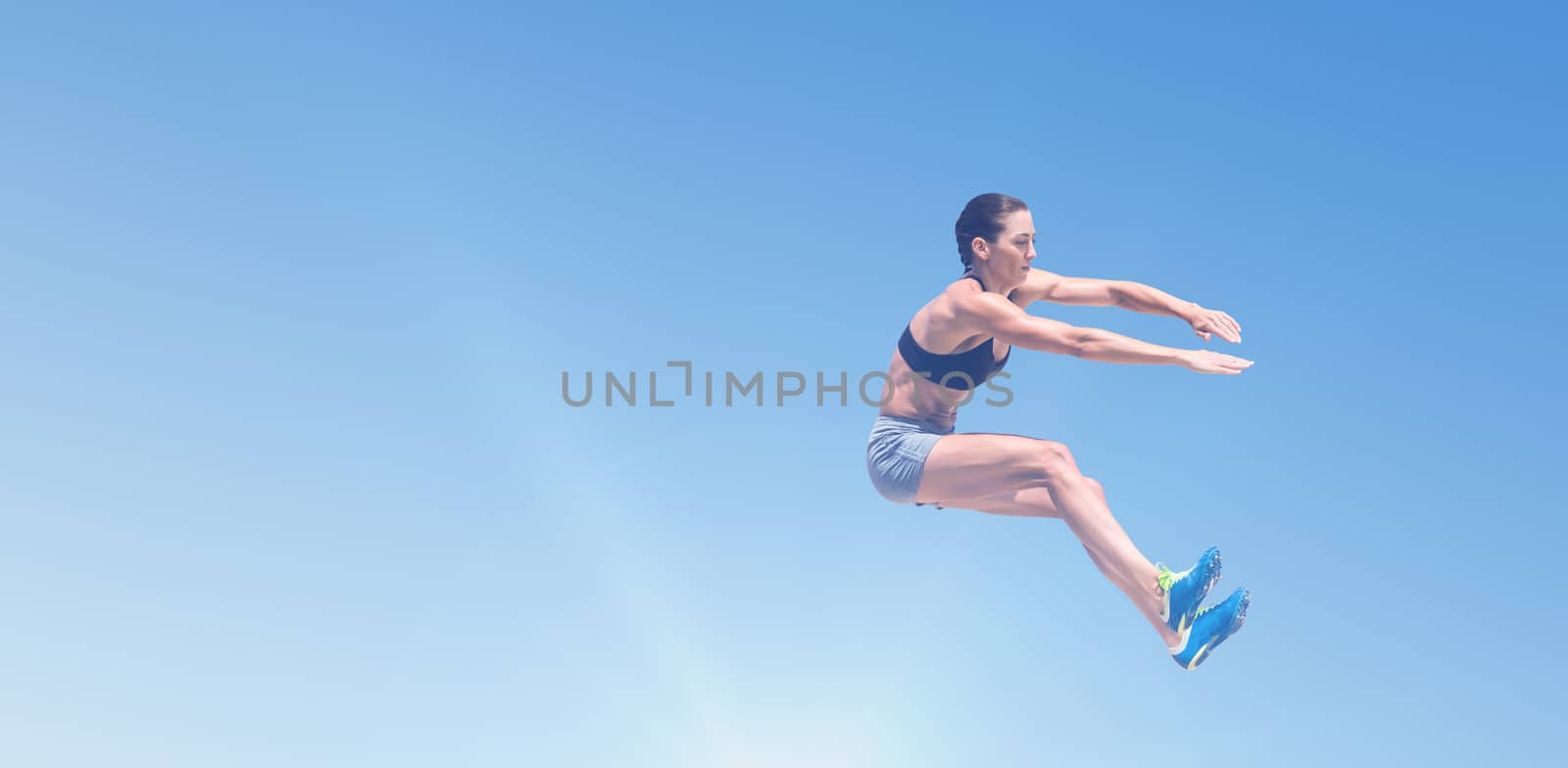 Sportswoman jumping on a white background against scenic view of blue sky