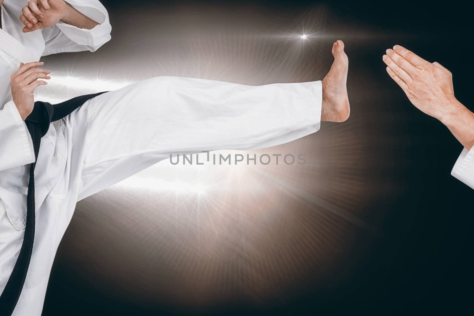 Female athlete practicing judo against spotlights