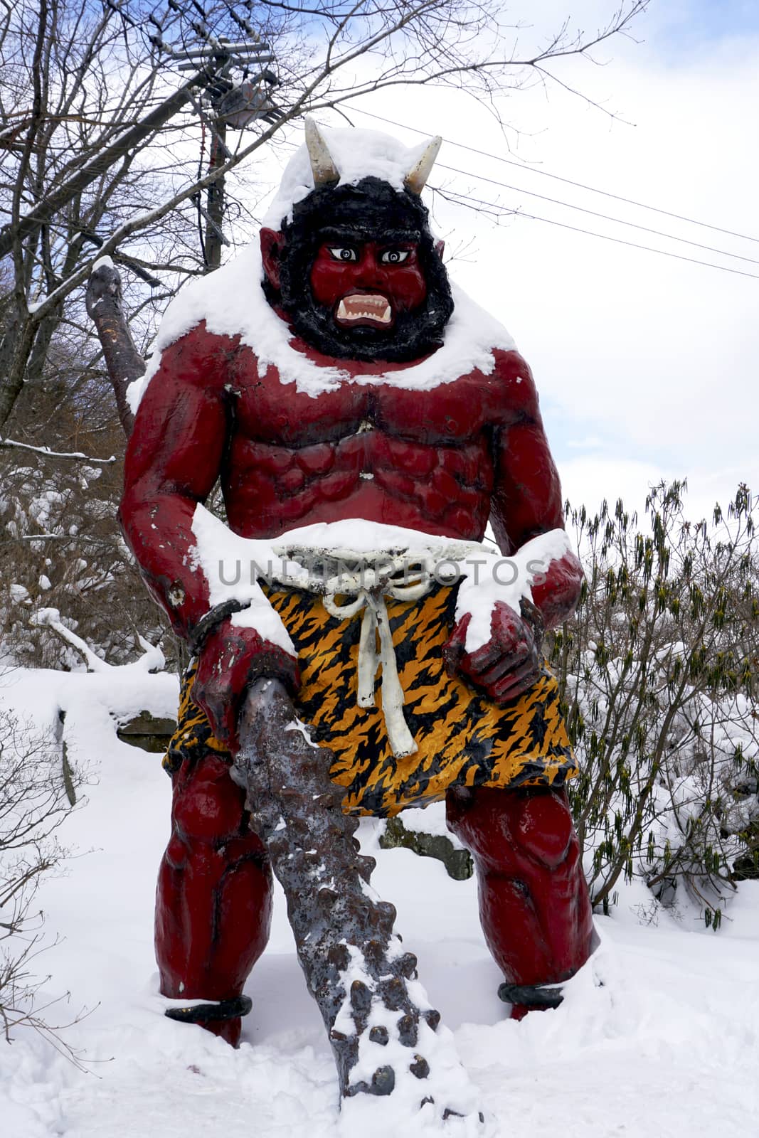 Red giant myth sculpture at Noboribetsu onsen snow winter national park in Jigokudani, Hokkaido, Japan
