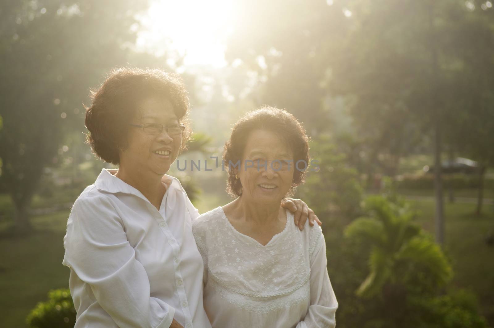 Portrait of healthy Asian seniors mother and daughter enjoying life at outdoor nature park, morning beautiful sunlight background.