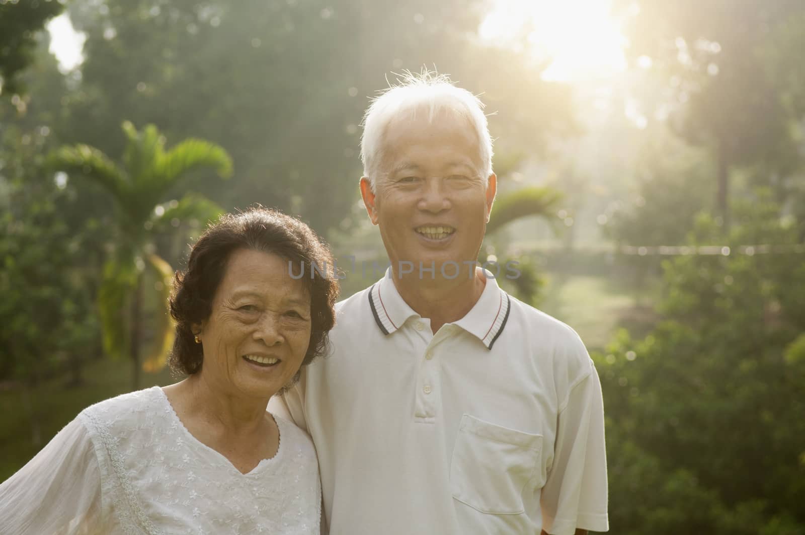 Portrait of healthy Asian seniors retiree couple having activities at outdoor nature park, morning beautiful sunlight background.