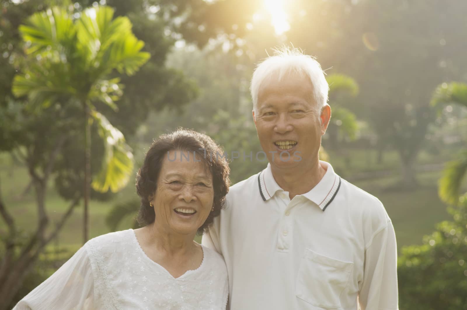 Portrait of healthy and happy Asian seniors retiree couple having activities at outdoor nature park, morning beautiful sunlight background.