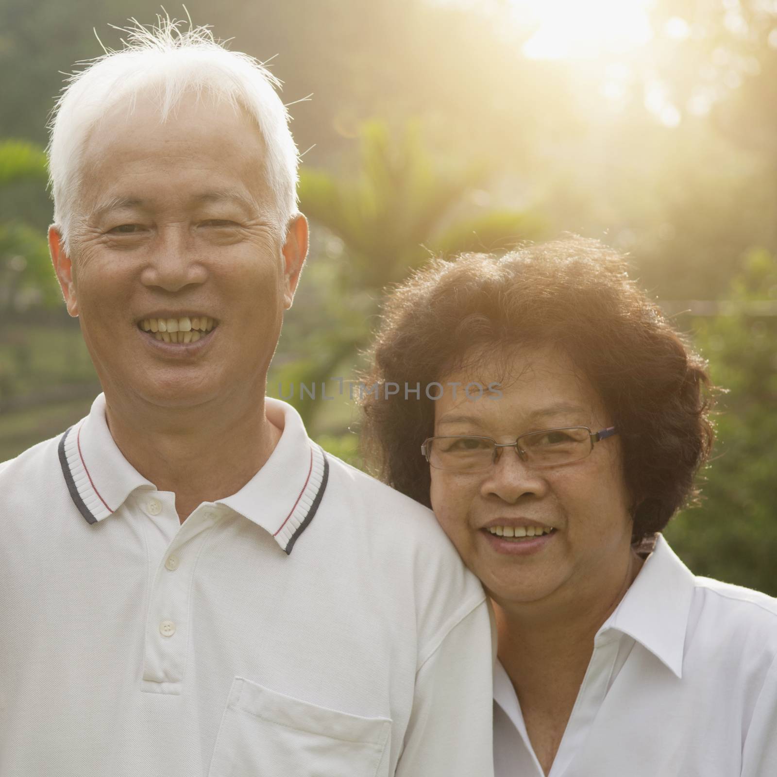 Portrait of healthy Asian seniors retiree couple enjoying life at outdoor nature park, morning beautiful sunlight background.