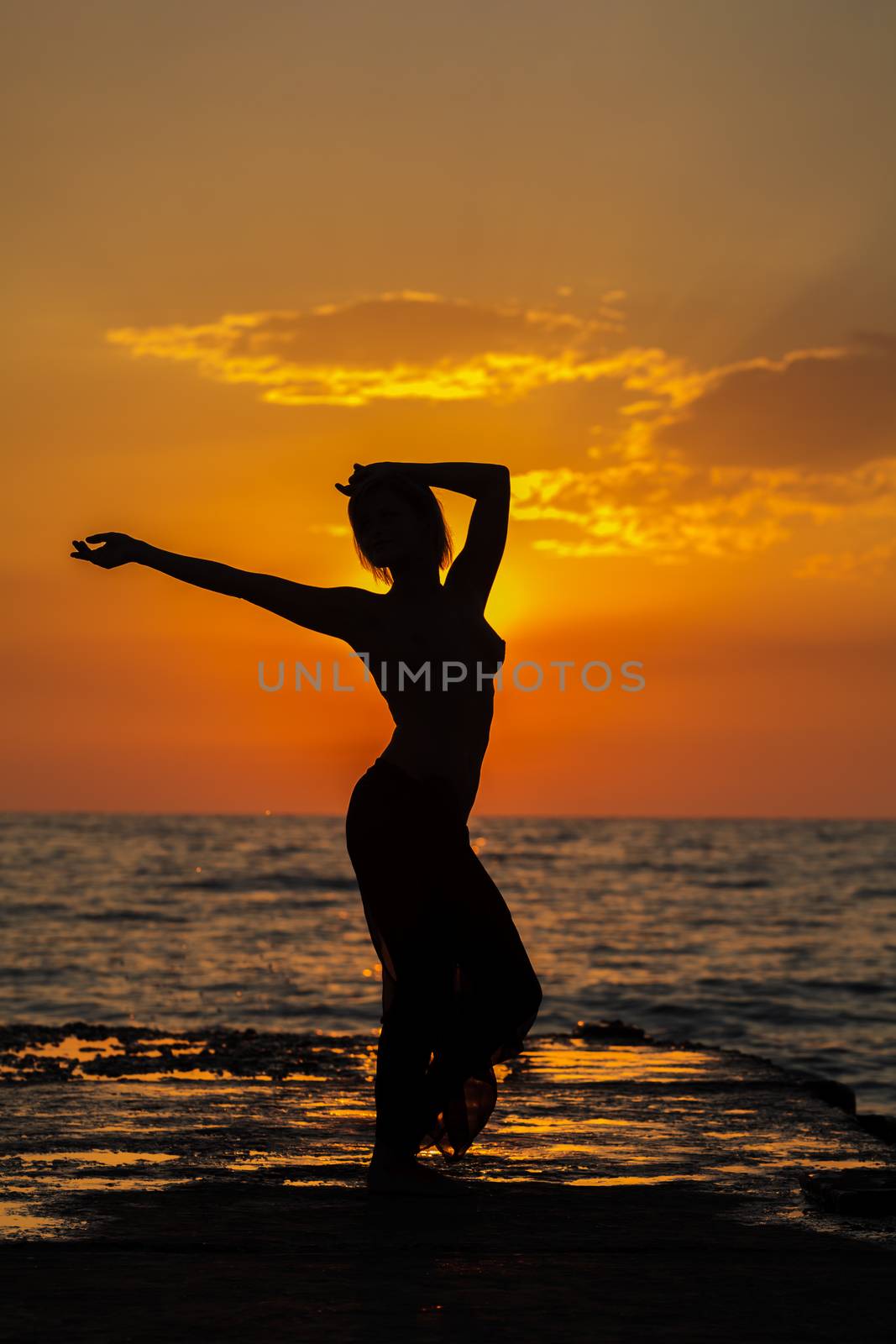 Girl jumping on a background of sea sunset