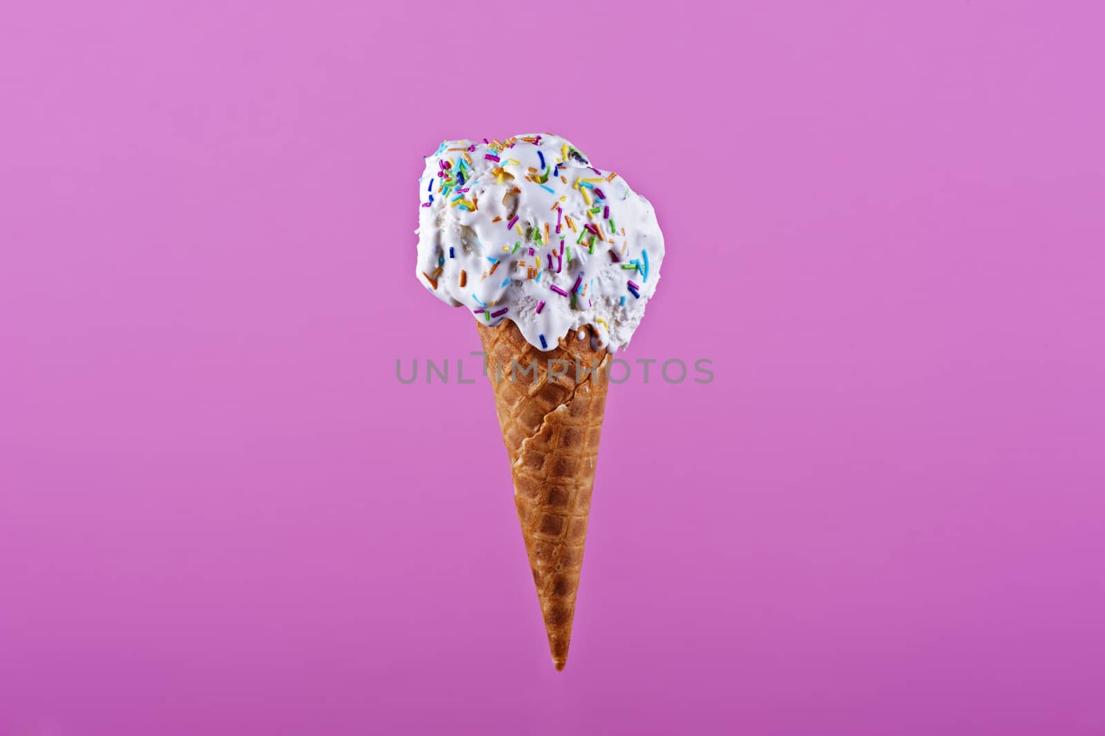 Ice cream in wafer cone isolated on pink background