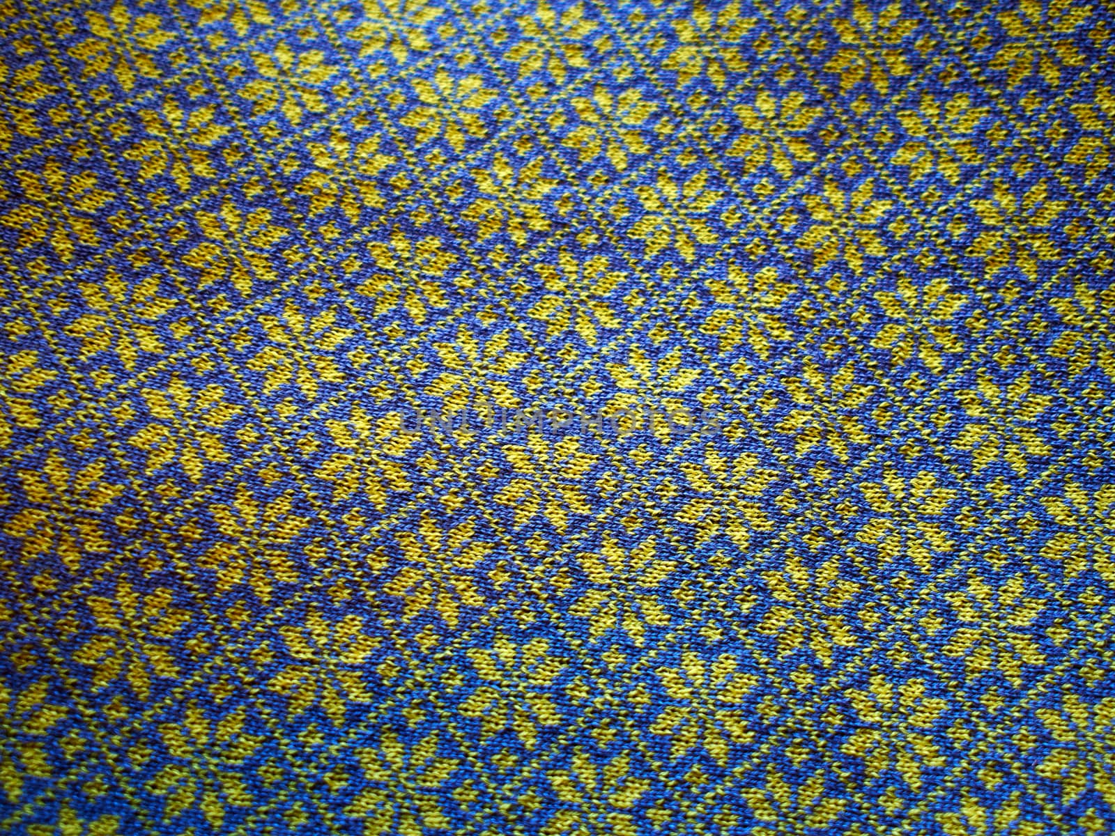 Closeup of a handmade wool sweater with Icelandic traditional typical pattern in blue and yellow colors