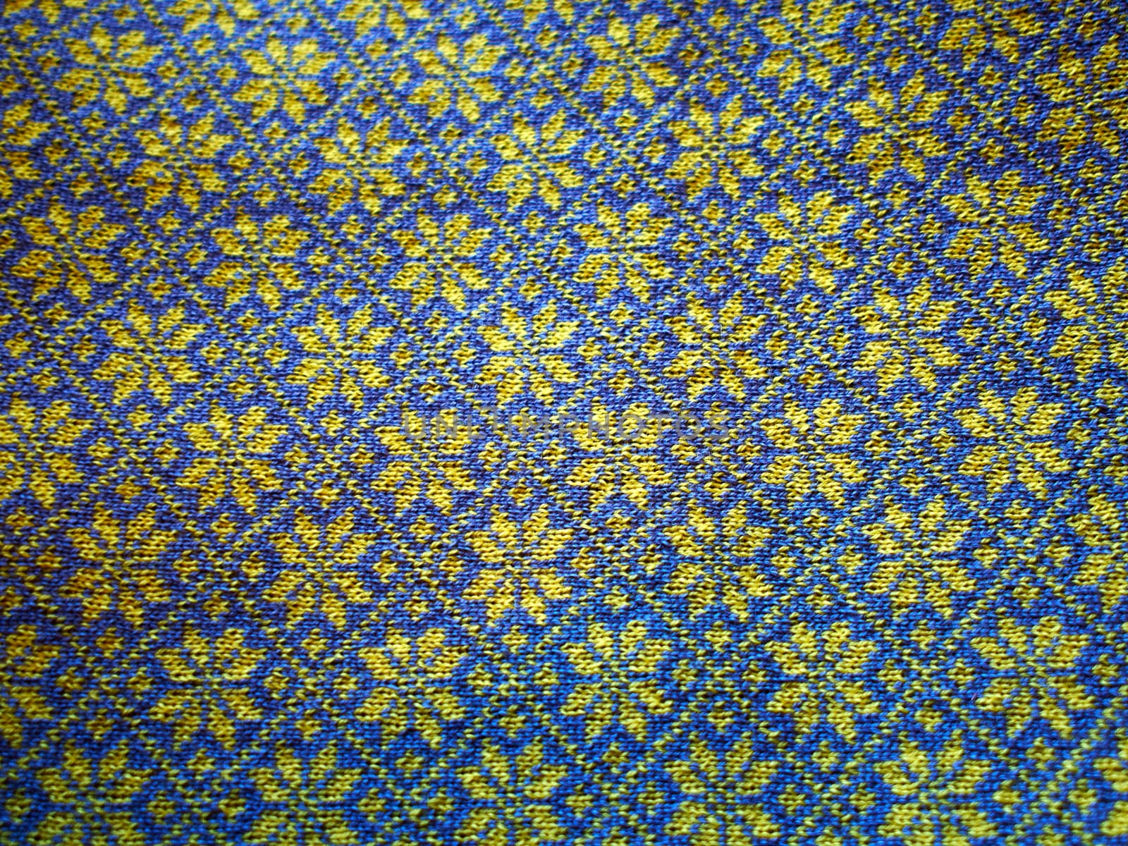 Closeup of a handmade wool sweater with Icelandic traditional typical pattern in blue and yellow colors