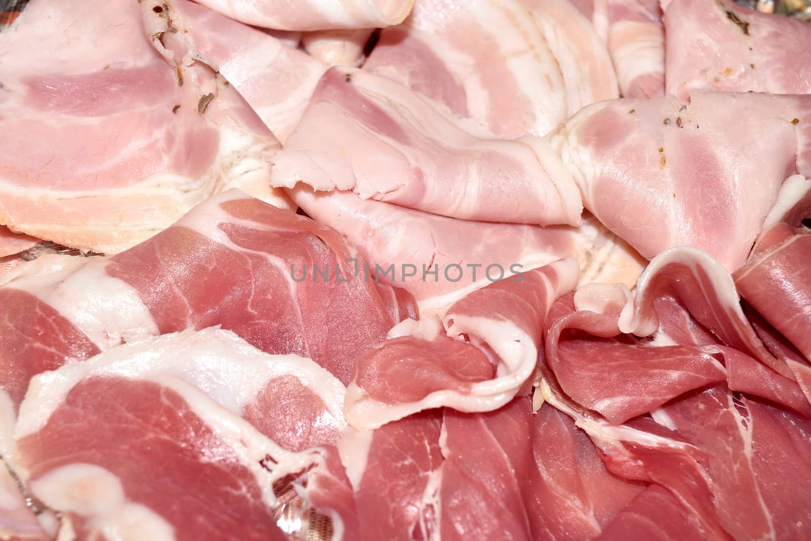 dish with thin slices of parma ham and roast pork cured meat