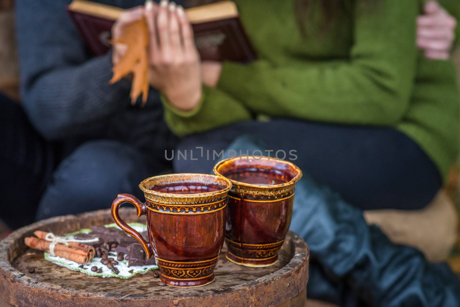 two cups of coffee are on wooden barrel