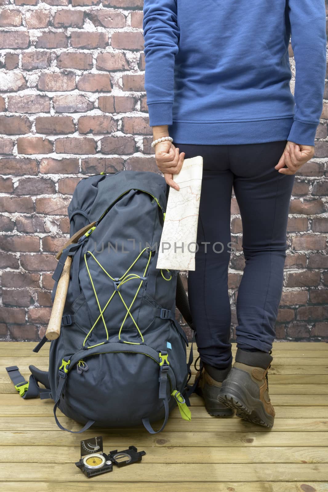 Woman with Hiking equipment, rucksack, boots and backpack. Concept for family hiking. Colorful background.