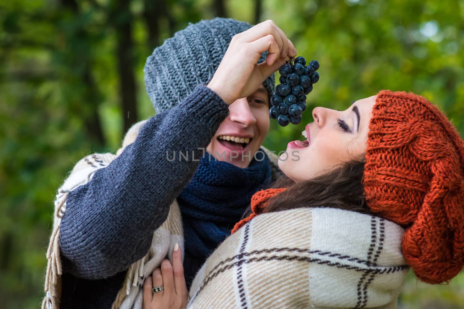 young couple eats grapes in the garden