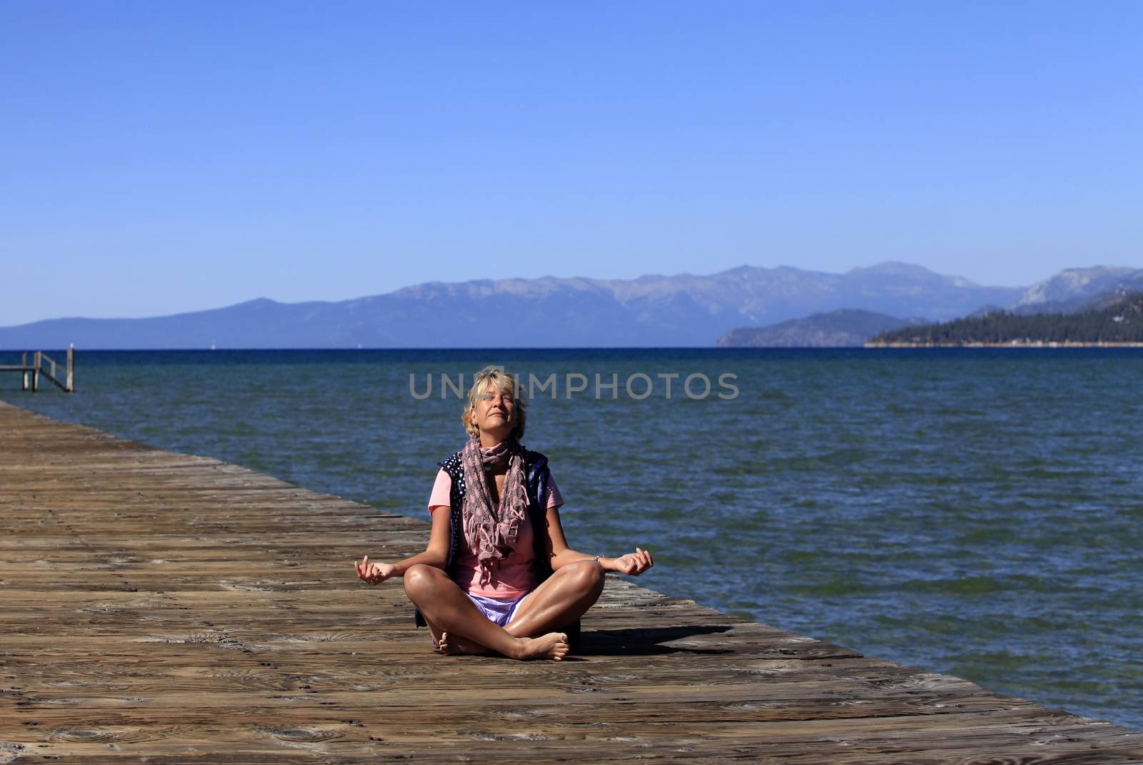 Meditation girl yoga on the beach on Lake Tahoe