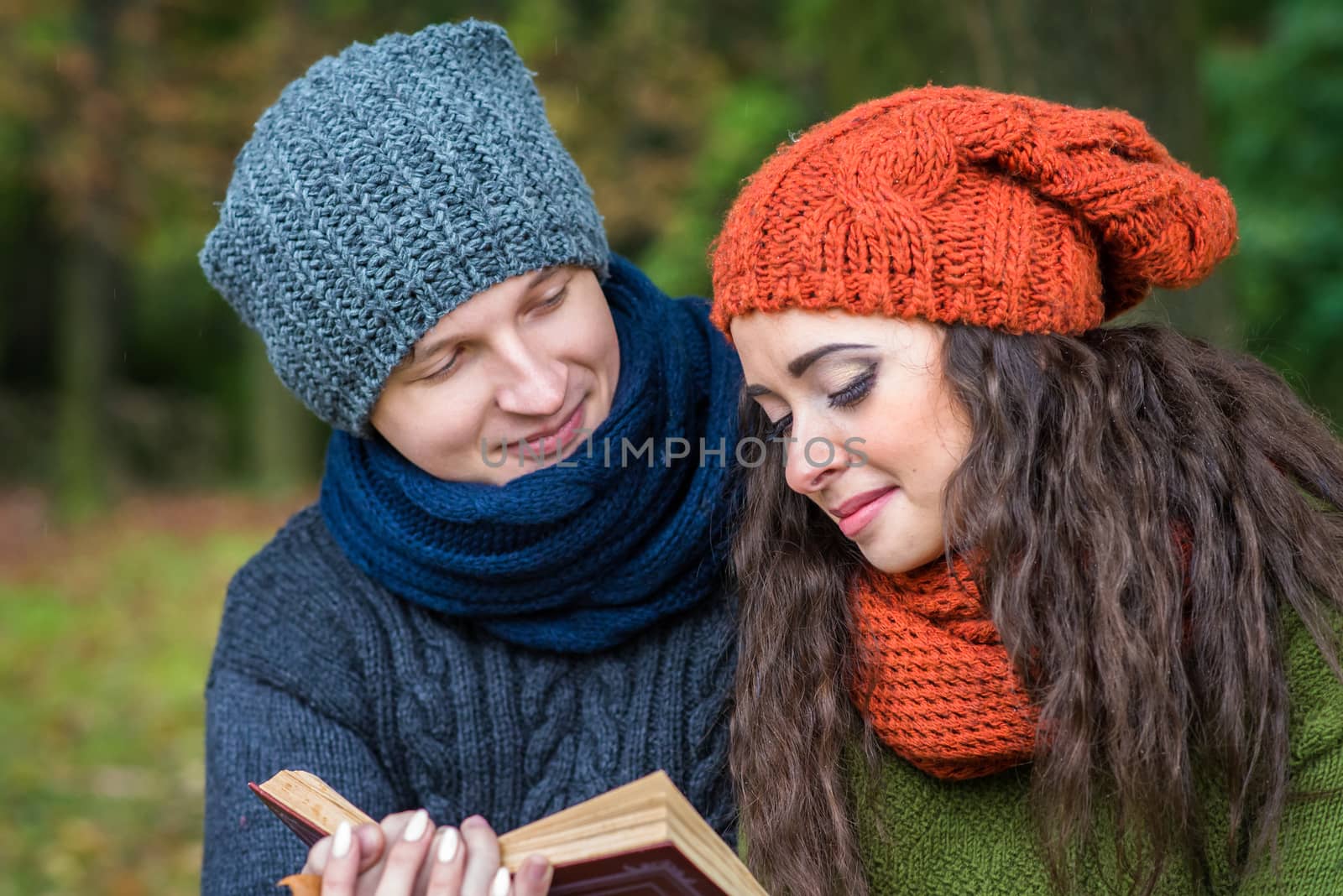 loving couple reads a book in the autumn garden