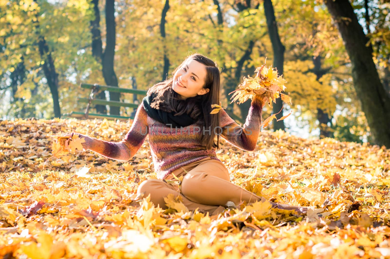 beautiful girl in autumn Park keeps yellow leaves