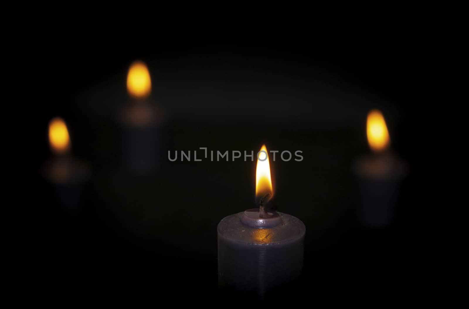burning candles, dark background, close up on the flame