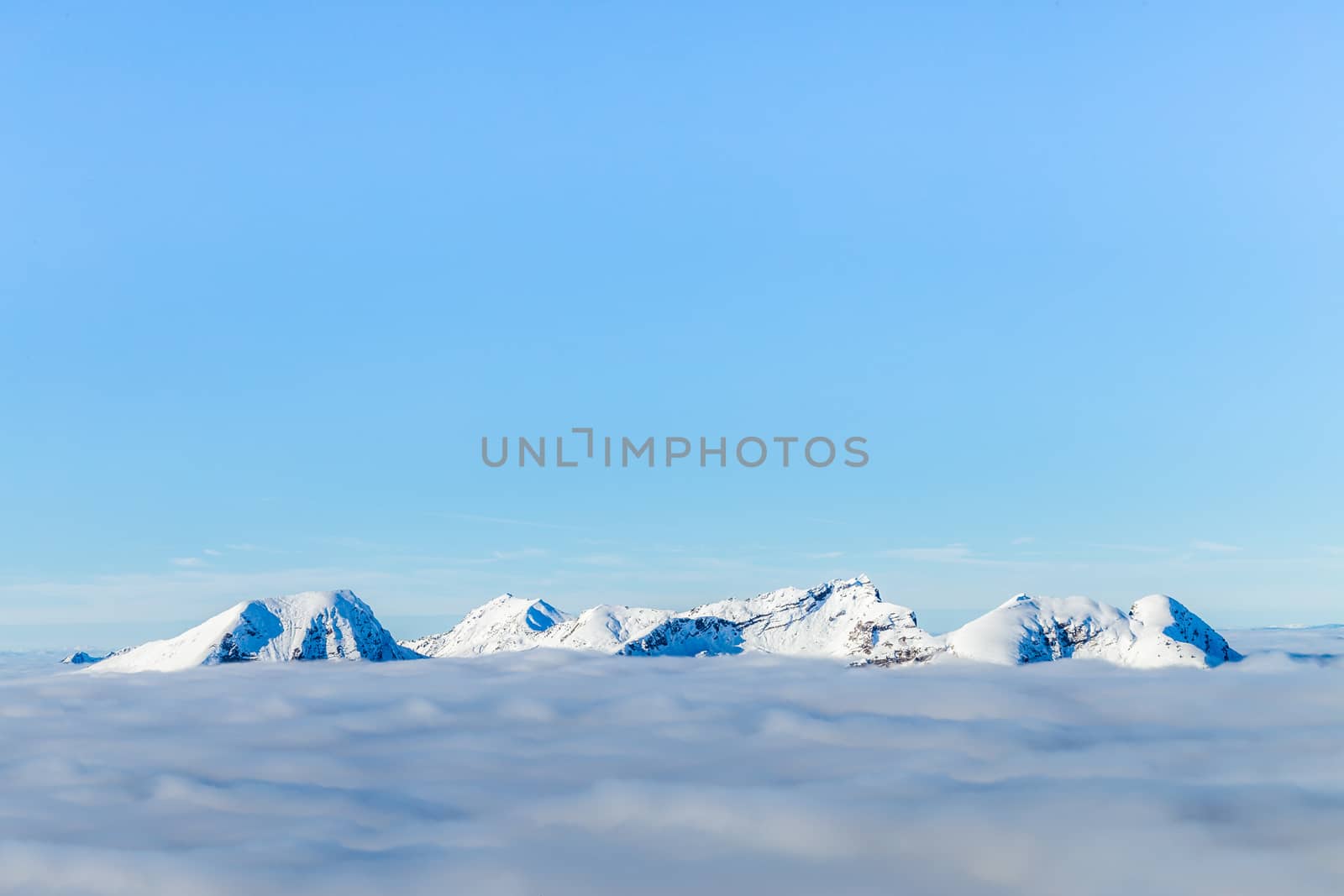 Snowcaped mountain tops peaking above the clouds