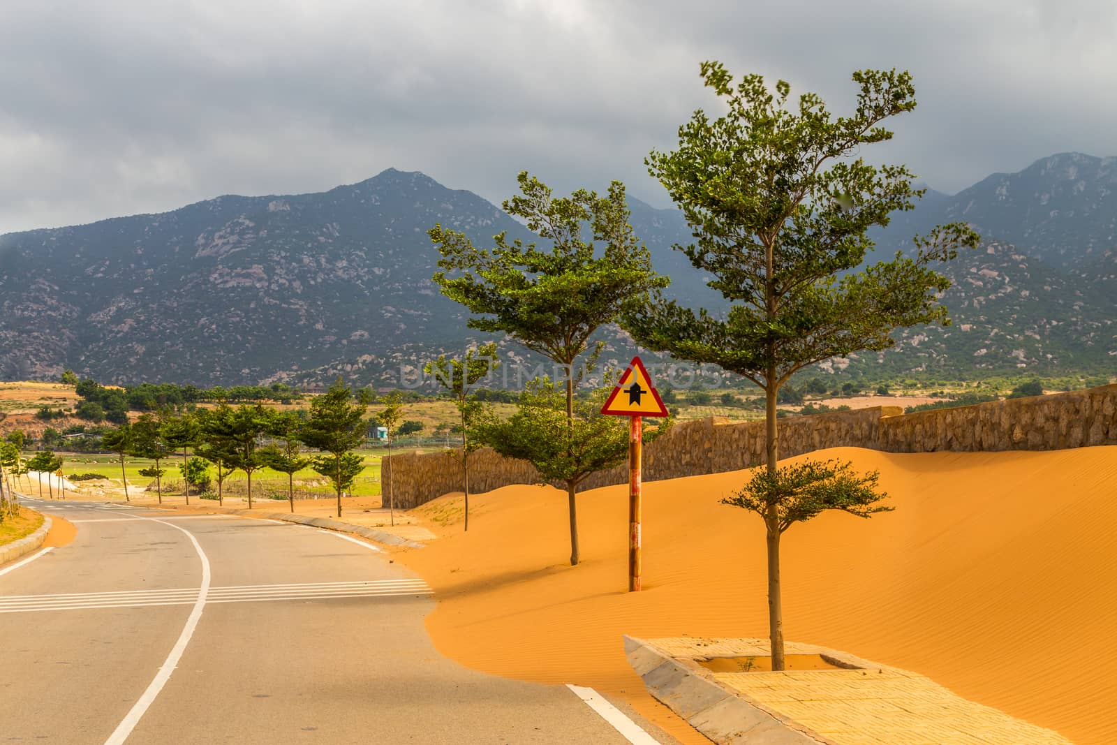 Sand on an empty road by kenzo85