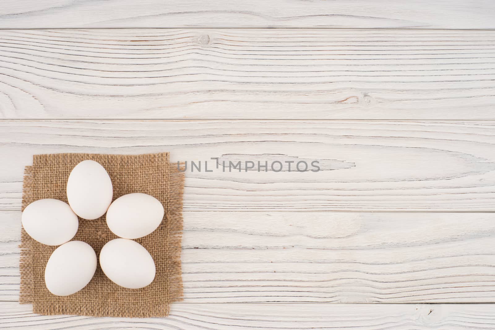 Chicken eggs on white old wooden table.  by DGolbay