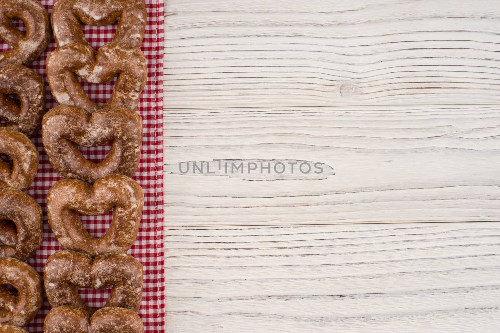 Gingerbread heart cookies on a wooden white background. Top view.