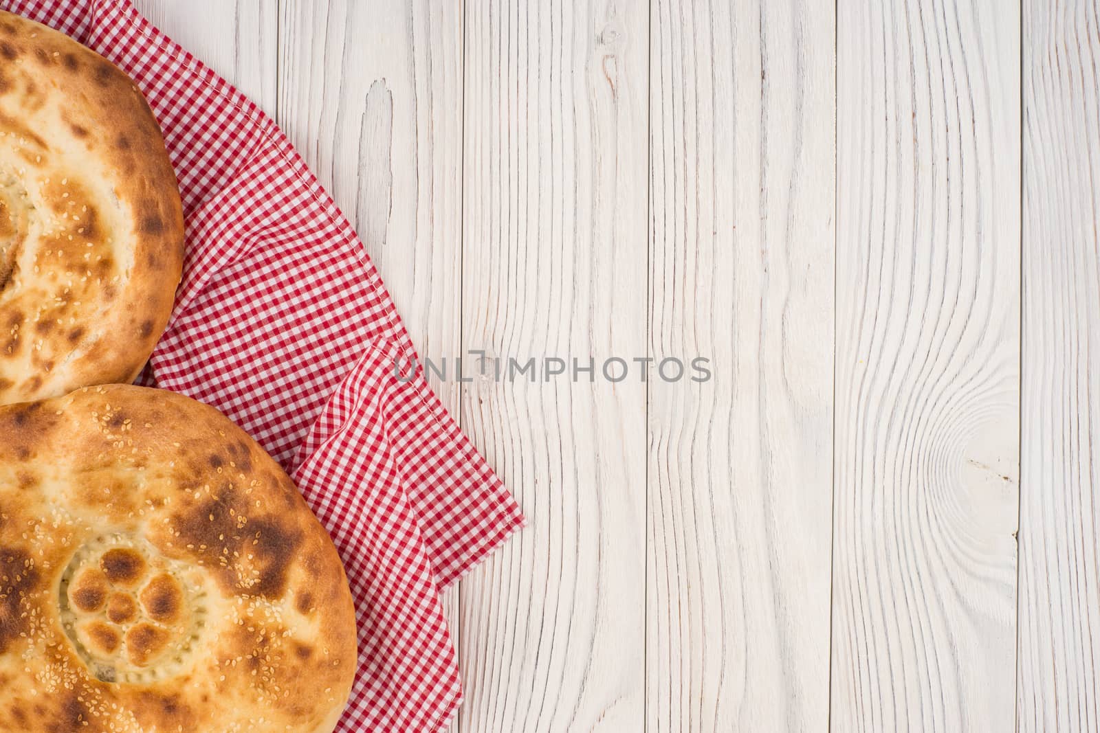 Uzbek bread on old white wooden table. Top view.