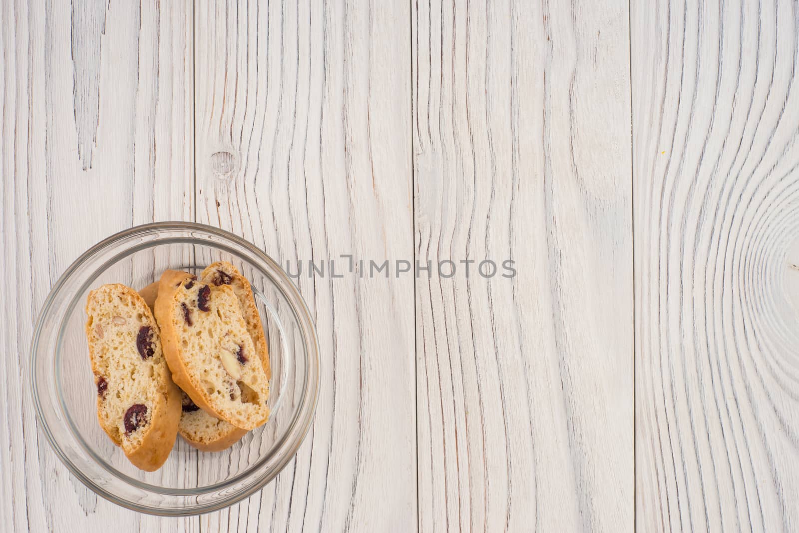 Biscuits in a glass bowl on old white wooden table. Top view.