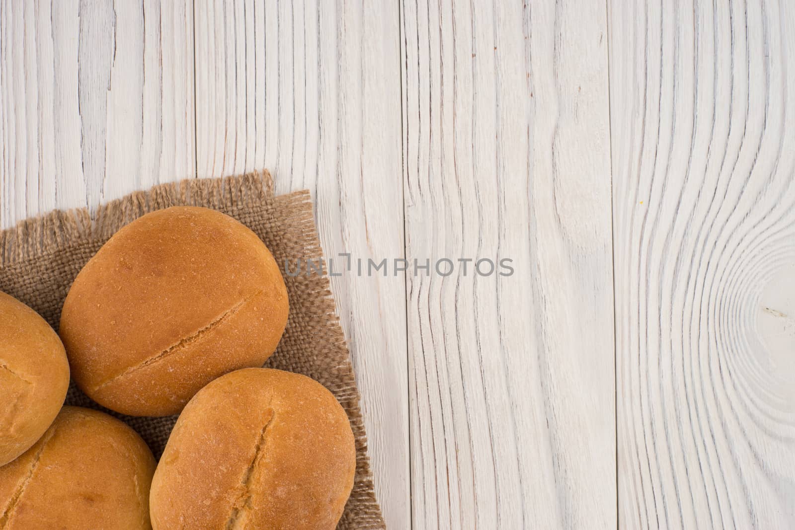 Hamburger buns on white old wooden table.  by DGolbay